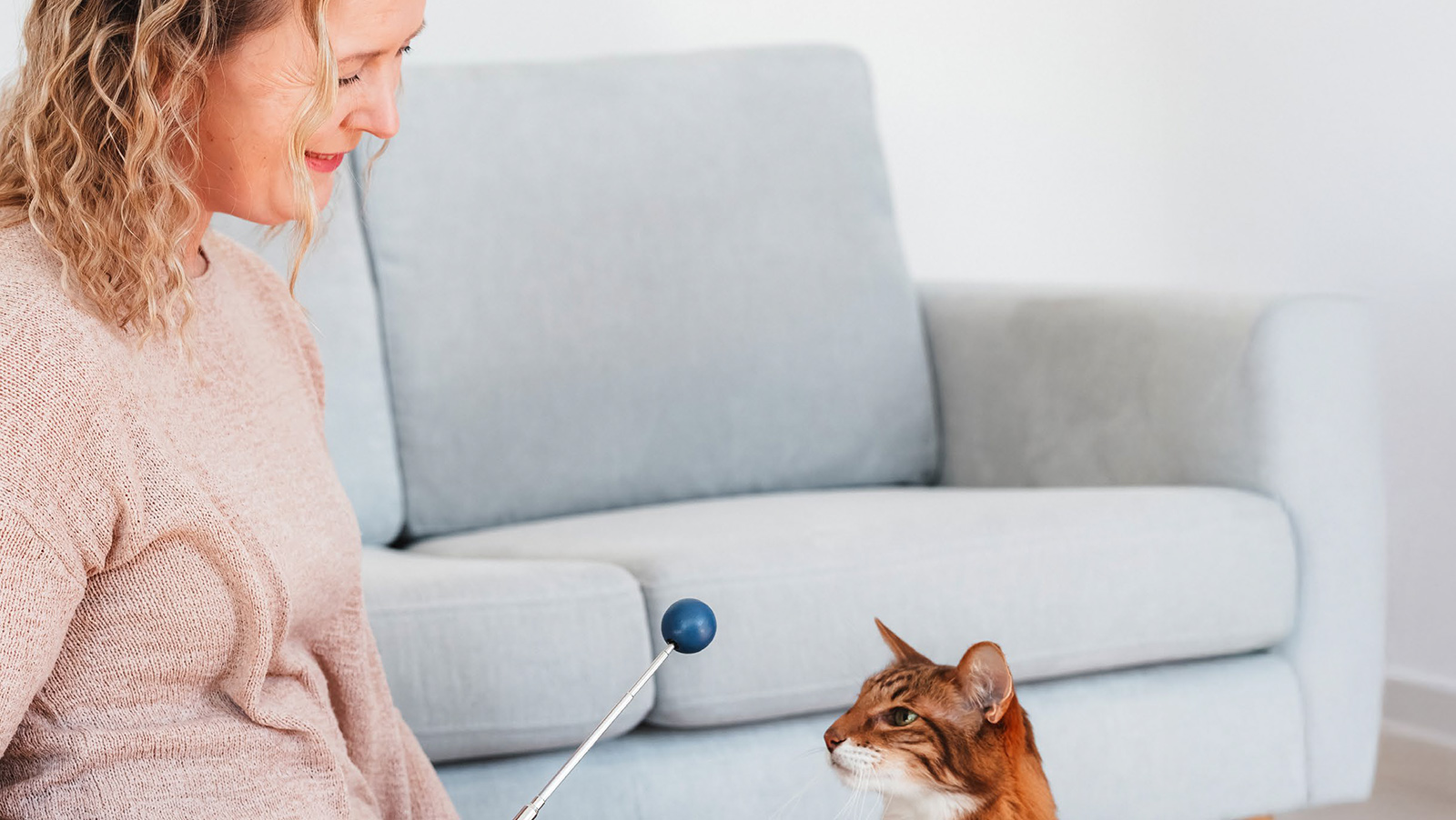 Nainen leikkii kissan kanssa